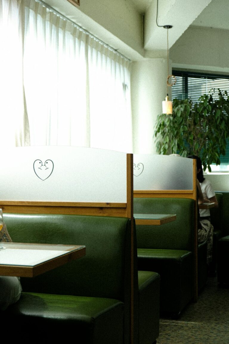 Vintage diner booths with green seating and heart decor create a cozy ambiance.